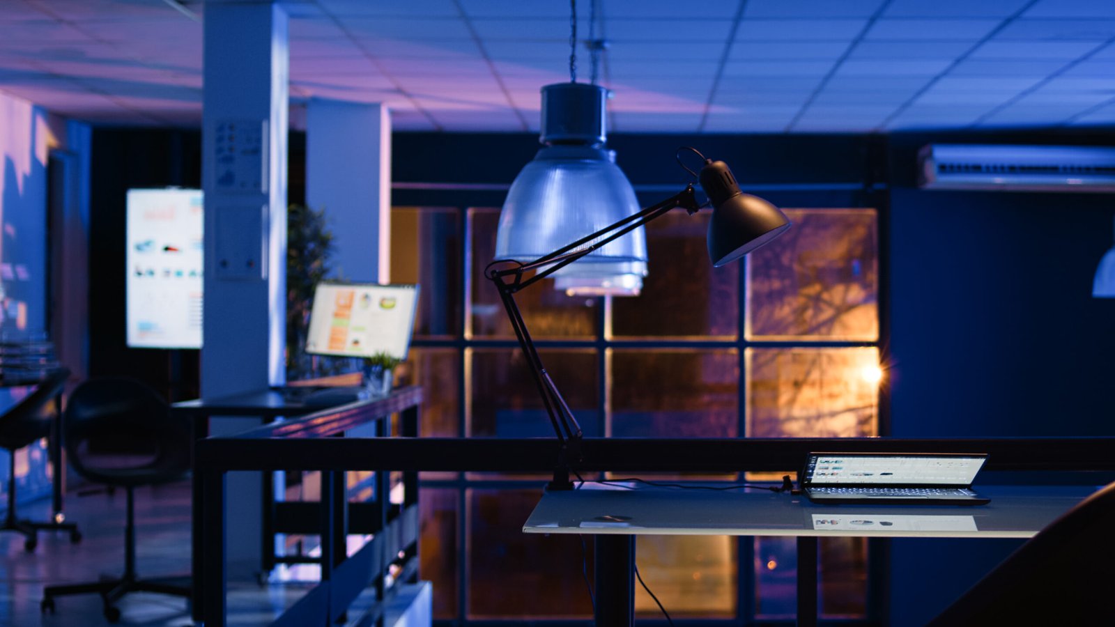 empty office with analytics diagrams screen running economy statistics computers business space startup company with research plans charts late night handheld shot